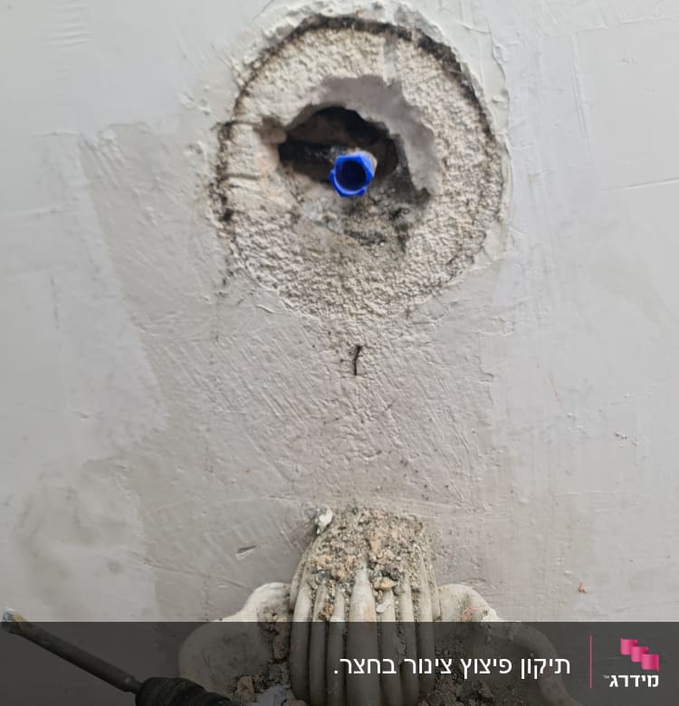 קיר עם חור וצינור כחול, מקדחה וכלי עבודה